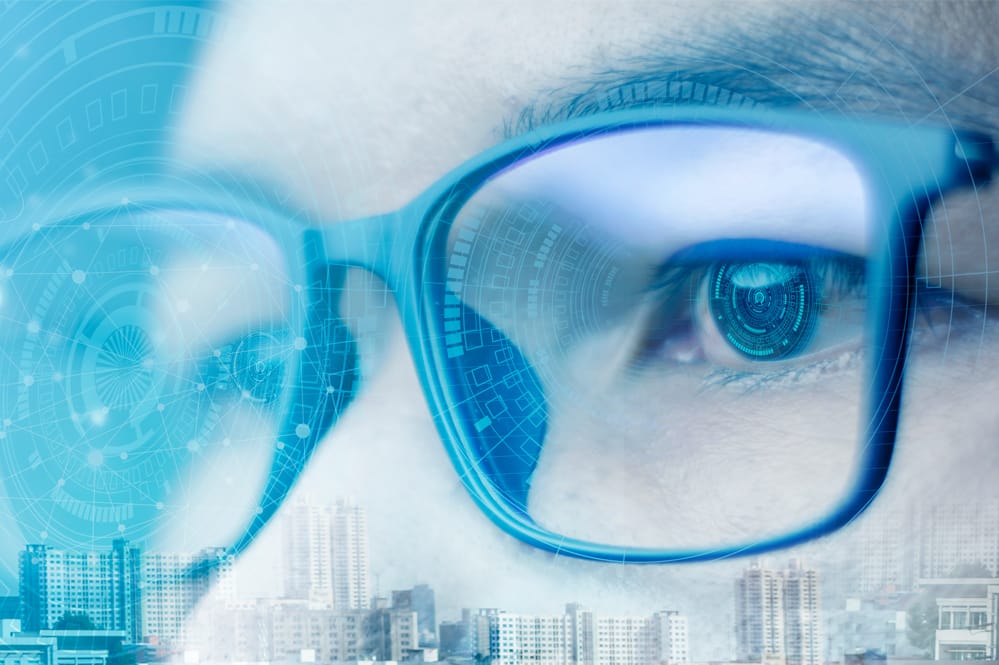 Futuristic image overlayed on picture of person with glasses
