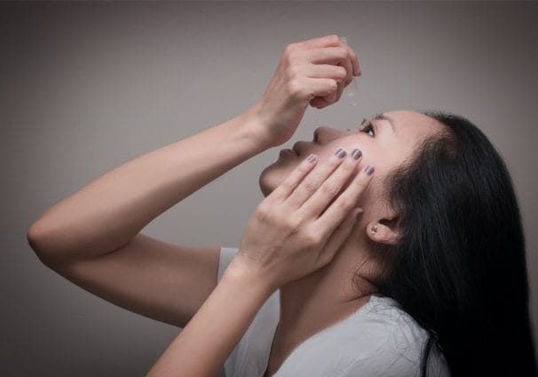 woman using eye drops