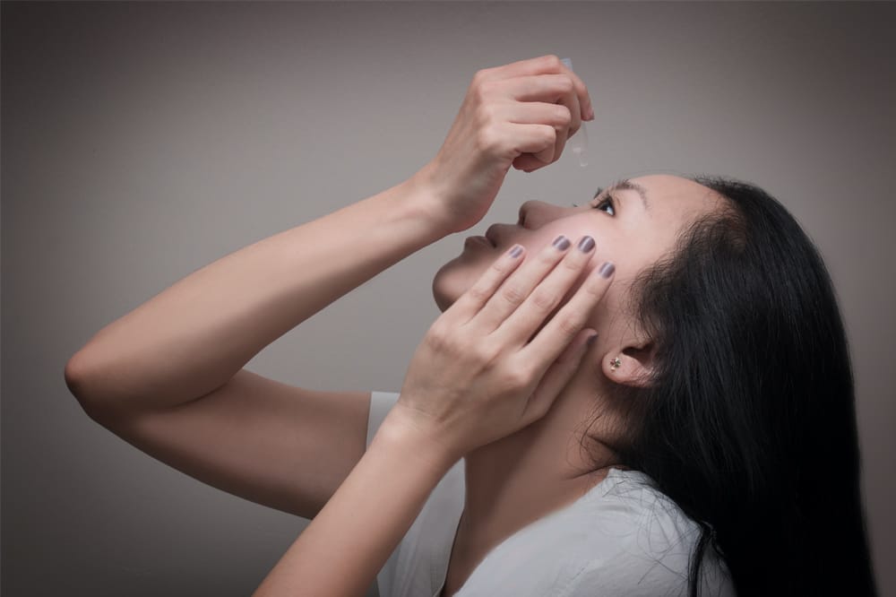 woman using eye drops