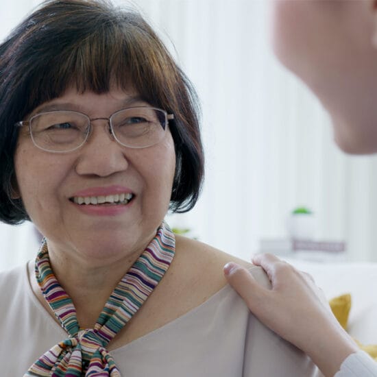 Image shows an older woman being comforted by a health professional after her glaucoma diagnosis.