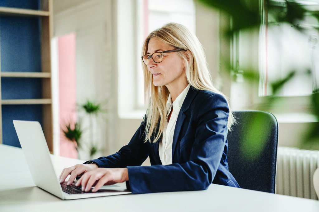 Businesswoman using laptop in office wearing occupational lenses