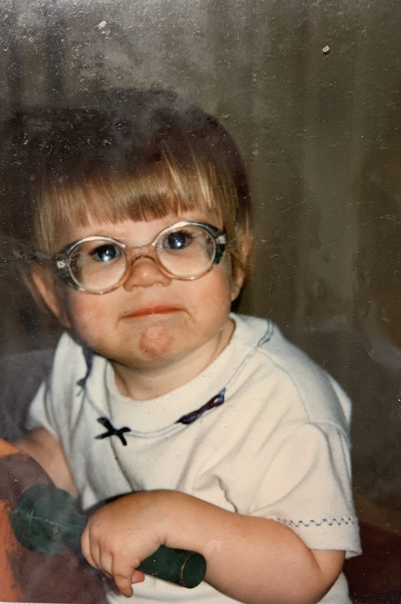 Abbie Madden at three years old. She is wearing thick glasses.