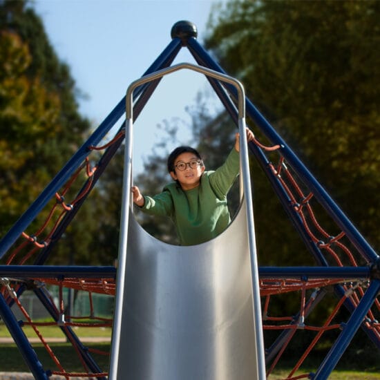 child on slide in playground wearing MiyoSmart
