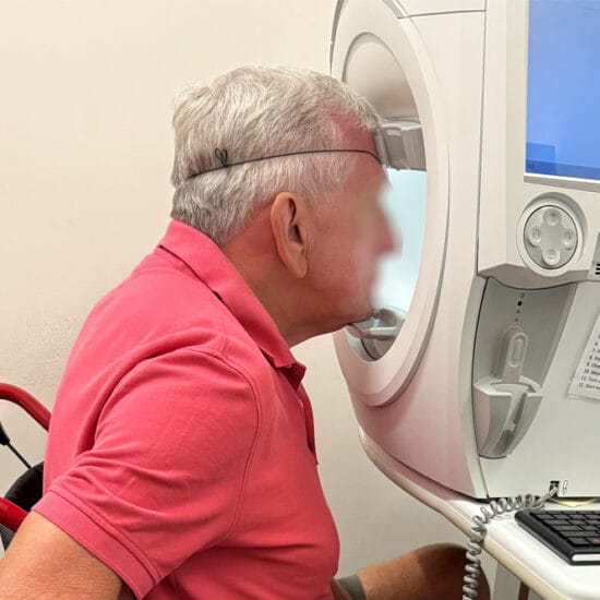 Patient in a wheelchair undergoing visual field testing