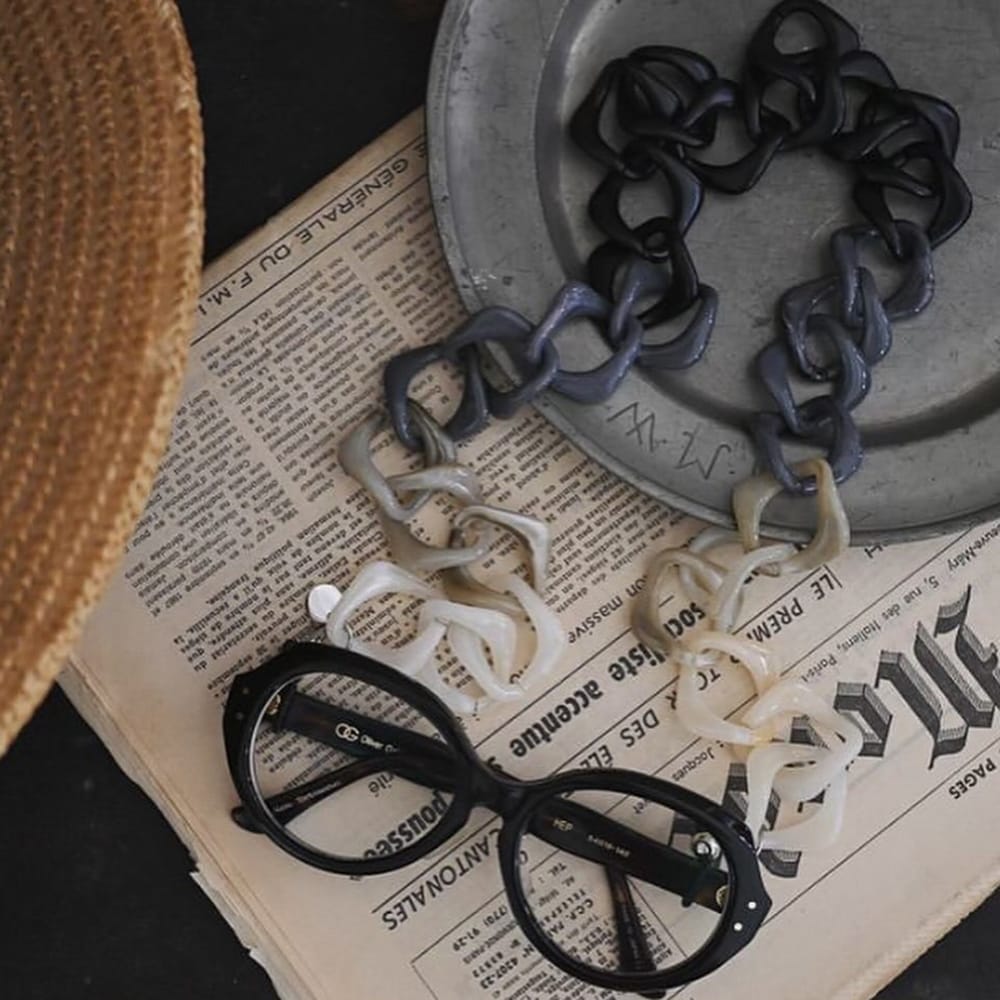 Coti Vision optical accessories - eye chains with glasses resting on newspaper