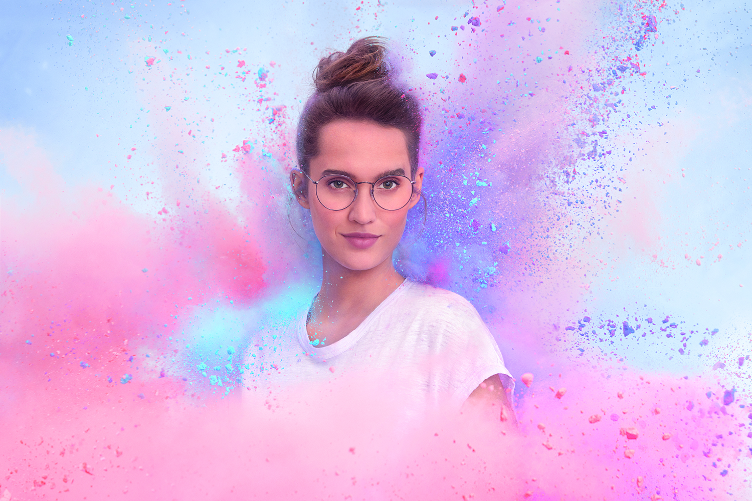woman wearing glasses surrounded by pink and purple colour. Glasses have Crizal Sapphire HR by EssilorLuxottica lens coatings