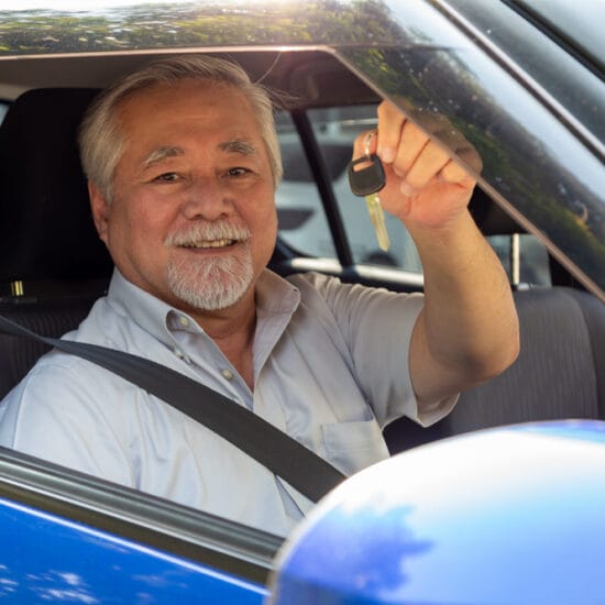 Man in drivers seat holding up keys illustrating fitness to drive.