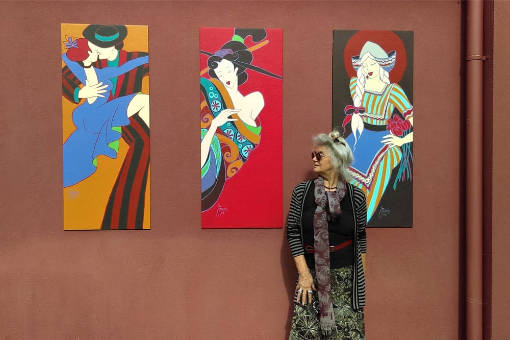 Jan Francis standing against her artworks