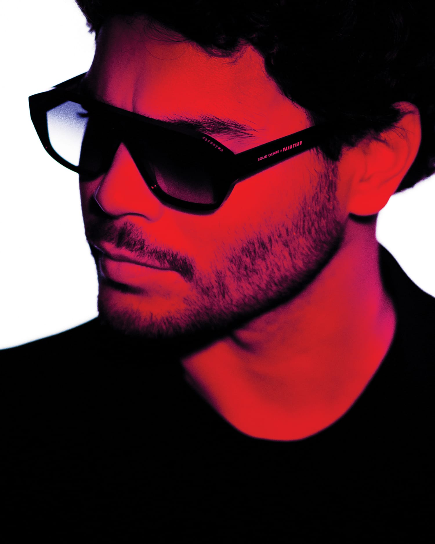 Model wearing VAANYARD x Solid Ochre frames. Image is shaded red.