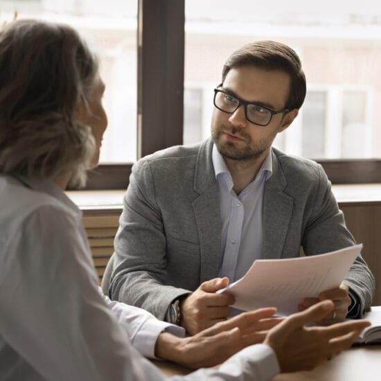 two people talking at a table, signifying intraprofessional collaboration.