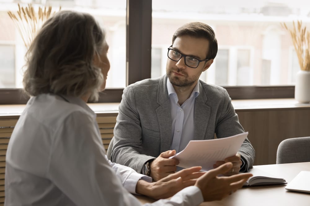 two people talking at a table, signifying intraprofessional collaboration.