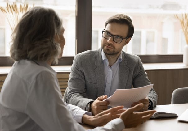 two people talking at a table, signifying intraprofessional collaboration.