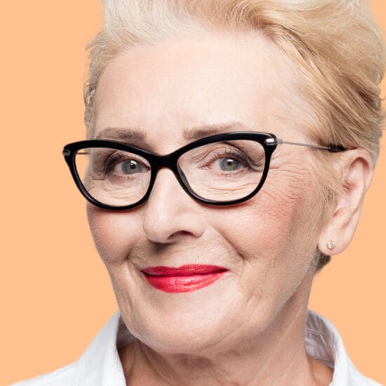 Older woman in glasses wearing cosmetics