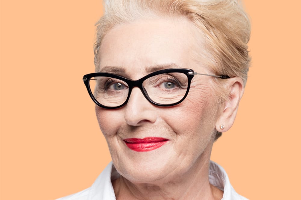 Older woman in glasses wearing cosmetics
