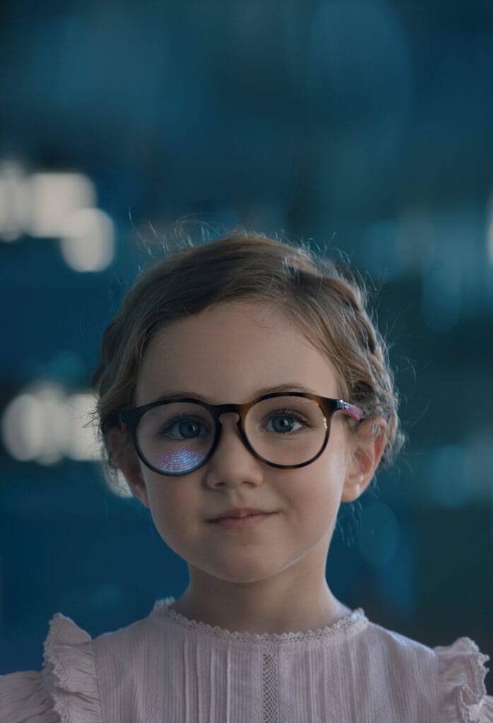 Girl wearing glasses with Essilor Stellest lenses for myopia management.