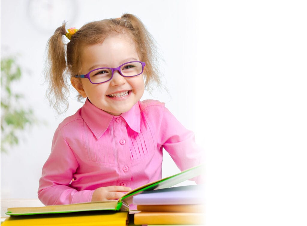 young girl in glasses reading book and smiling