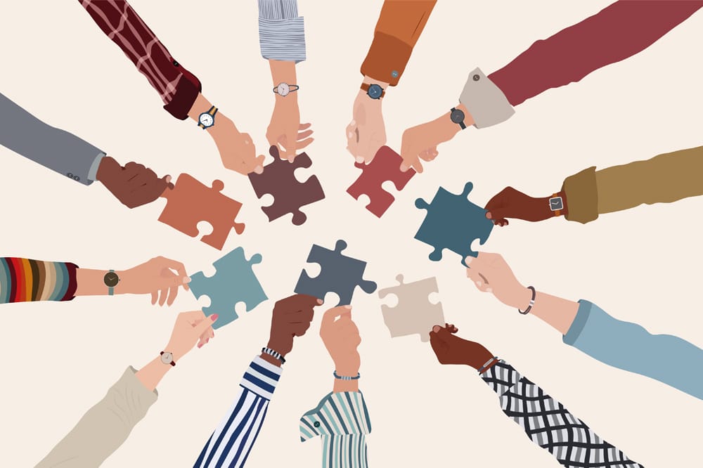 graphic of hands in a circle with different pieces of jigsaw representing collaboration