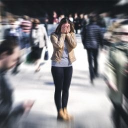 image of woman appearing stressed - the peopel around her are blurred,