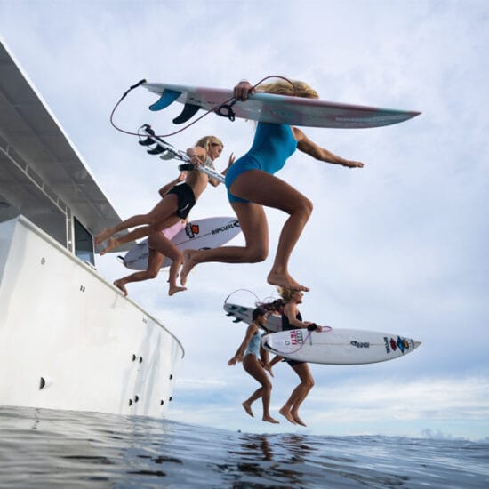 SURFERS jumping into water