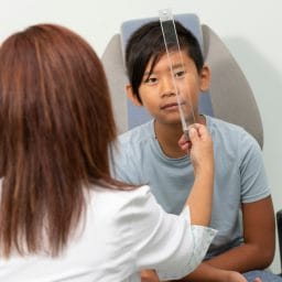 optometrist performing paediatric eye care exam