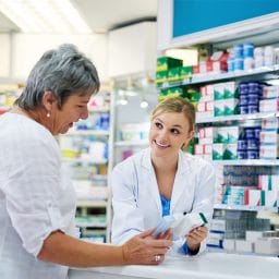 person at a pharmacy talking to a pharmacist
