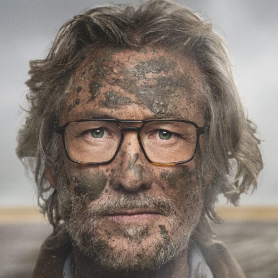 man covered in dirt but in clean glasses