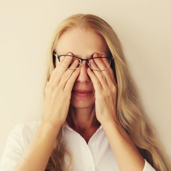 Person holding hands to eyes because she's suffering from dry eye