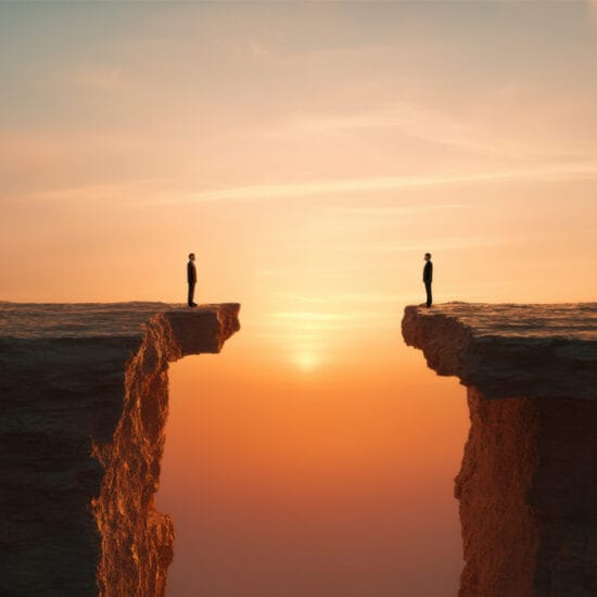 two people sanding on opposite sides of a cliff representing business divorce
